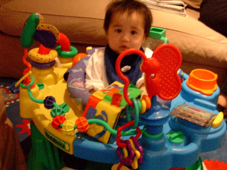 Photo: My nephew, Nicholas, sitting in his activity centre with a concerned expression on his face.