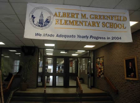 Photo: School hallway showing banner for Albert M. Greefield Elementary School: 'We made adequate yearly progress in 2004'.