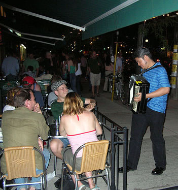 Photo: Joey deVilla playing accordion for some friends on a patio on College Street West, Toronto.