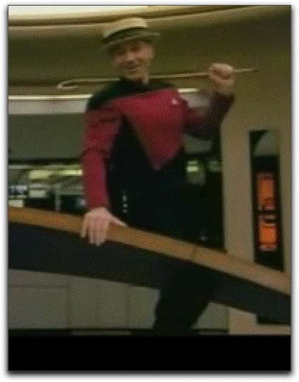 Photo: Captain Picard leaning against tactical console in straw hat and cane.