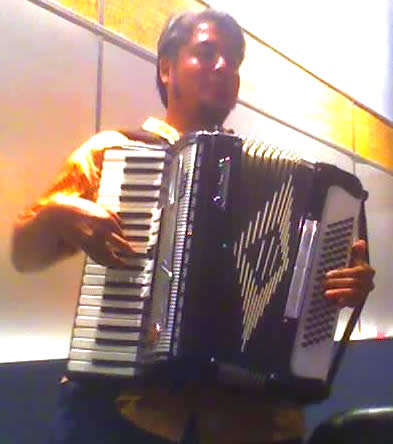 Photo: Joey plays accordion in the Tucows boardroom.