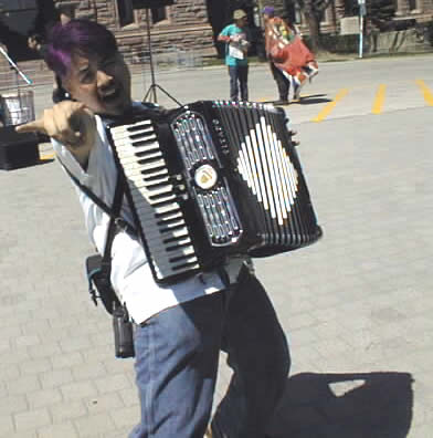 Joey throws the horns with his accordion at Queen's Park, May 1999.