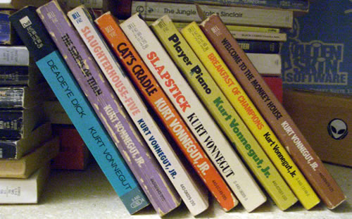 A set of dog-eared Kurt Vonnegut paperbacks: Deadeye Dick, The Sirens of Titan, Slaughterhouse Five, Cat's Cradle, Slapstick, Player Piano, Breakfast of Champions and Welcome to the Monkey House.