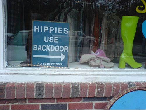 Sign in storefront: 'Hippies use backdoor - No exceptions'.