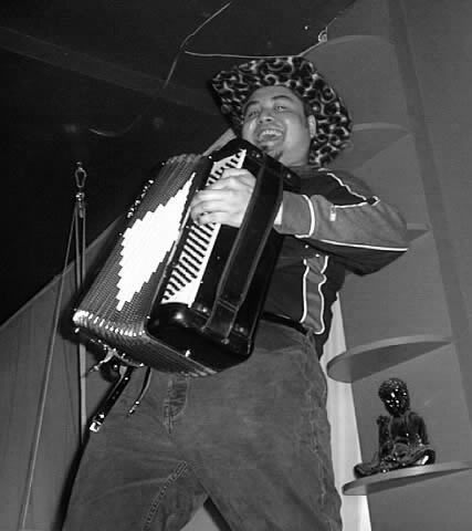 Joey deVilla plays accordion while go-go dancing on the bar at The Living Room.