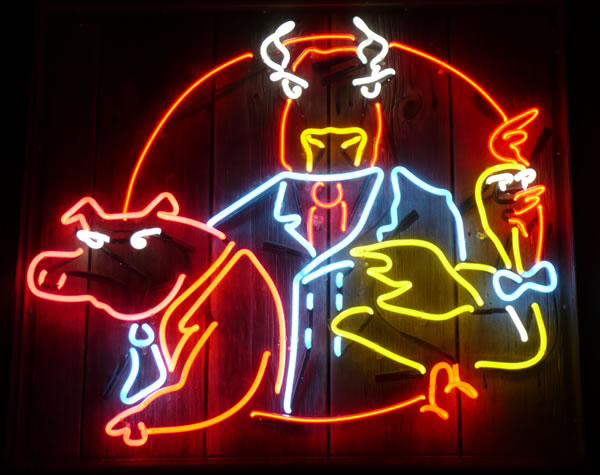 Neon sign from the Toronto barbecue restaurant “Cluck, Grunt and Low”, featuring a pig, cow and chicken in suits.