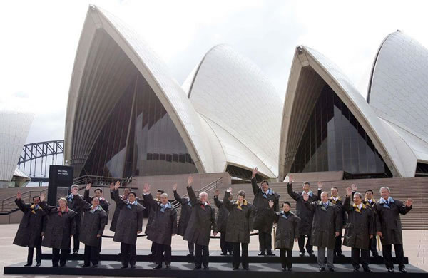 APEC leaders waving outside the Sydney Opera Hall; all are waving with their right hands except for George Bush