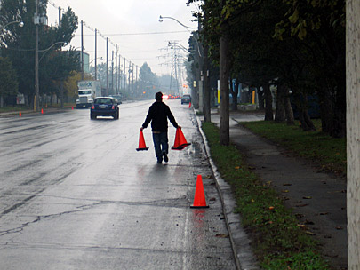 Photo of Impark employee placing pylons to block people from using free street parking
