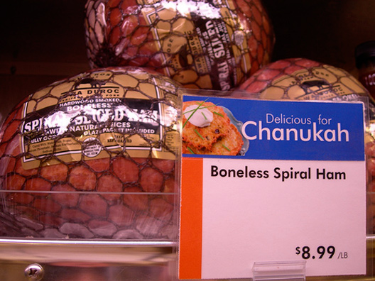 Grocery store shelves with ham and a sign labelled “Delicious for Chanukah”