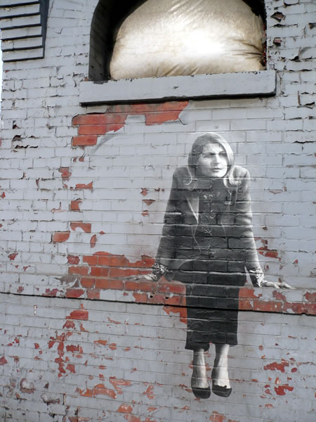 Photorealistic mural of a woman sitting down
