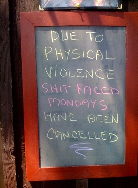 Chalkboard sign outside a bar: "Due to physical violance, Shit Faced Mondays have been cancelled."