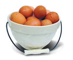 A ceramic bowl with handle, filled with brown eggs