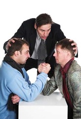 "Mediator" photo: guy in suit acting as a referee for two guys in suits arm-wrestling