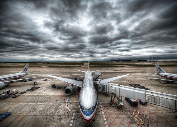 Airplanes on a tarmac under a cloudy grey sky