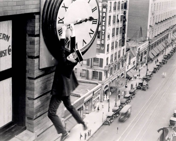 Buster Keaton hanging from the big hand of a building-mounted clock