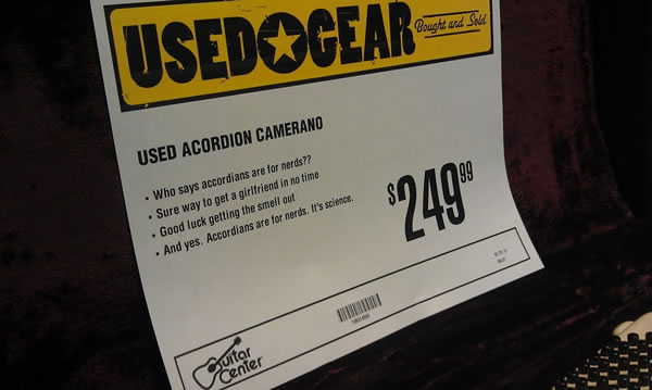 Guitar Center price sign: Used Acordion [sic] Camerano | Who says accordians [sic] are for nerds?? | Sure way to get a girlfriend in no time | Goo dluck getting the smell out | And yes, Accordians [sic] are for nerds. It's science.