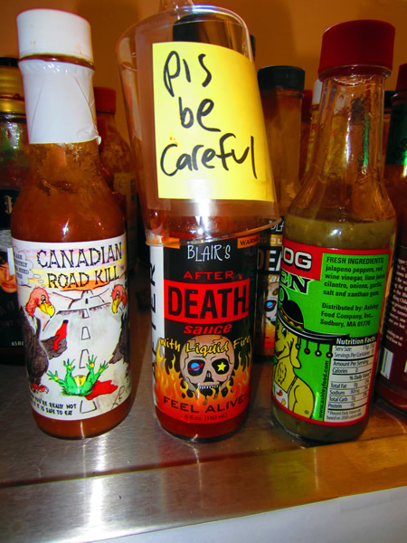Close up of bottle of hot sauce, with the label "Please be careful"