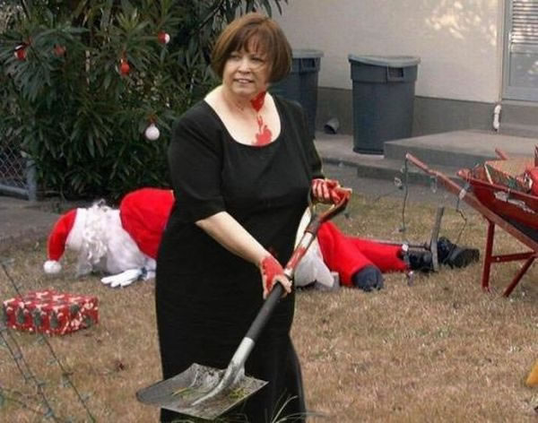 Santa lying face down in the background; blood-covered woman holding shovel in the foreground.