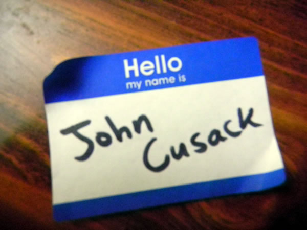 Blue "Hello my name is" sticker with "John Cusack" written in