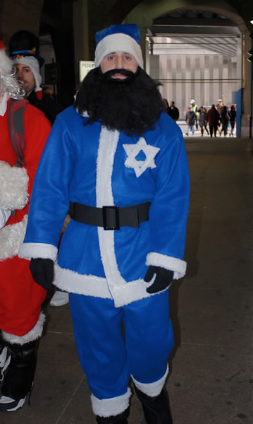 Santa with a blue suit and a Star of David, sporting a thick black beard