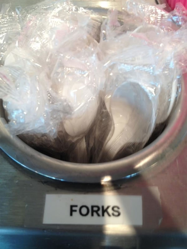 Spoons in a dispenser labelled "forks"