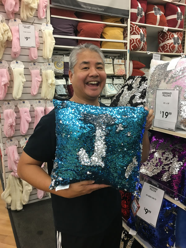 Joey deVilla posing with a throw pillow covered in sequins to form the letter 'J'.