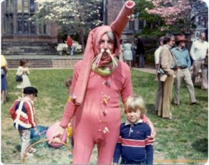 Guy in terrible Easter Bunny costume made of red long underwear standing with regretful child