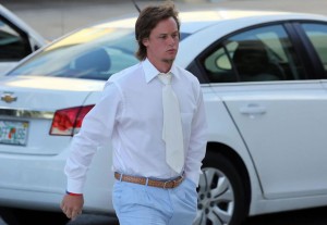 "Tayla the Manatee Slaya" walks to his court case in a white dress shirt, a '70's era wide white tie, brown golf belt, and baby blue slacks.