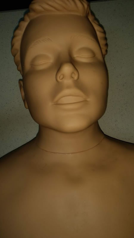 Close-up of medical mannequin face, which shows its eyes shut and mouth half-open