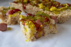 Photo: Rice krispies treats, but with cut-up hot dog embedded in them, and slathers with ketchup, mustard, and relish.