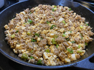 Photo: Cast iron pan full of ma po tofu (Cut-up tofu, ground pork, and spicy chili sauce, garnished with sliced green onion).