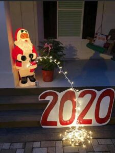 Photo: Light-up Santa “peeing” (by way of an arc of Christmas string lights) on the year 2020.