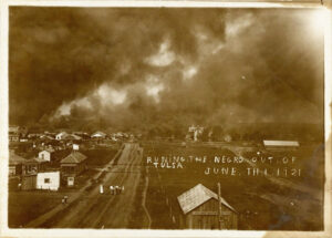 Photo depicting a burning cityscape during the Tulsa Race Massacre on June 1, 1921. Handwritten caption reads “Runing [sic] the negro out of Tulsa June th 1 [sic] 1921.””