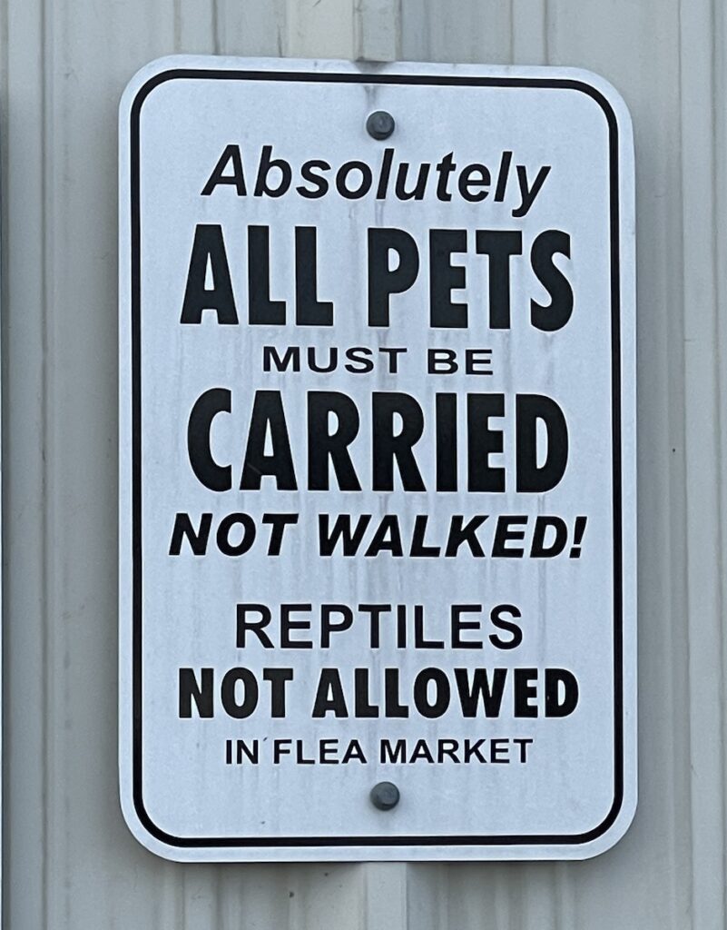 Sign: “Absolutely ALL PETS must be CARRIED not walked! Reptiles NOT ALLOWED in flea market””