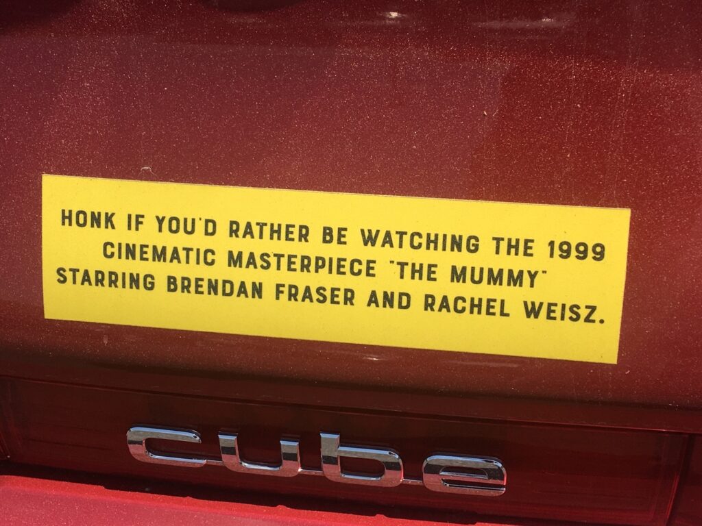 Bumper sticker that reads “Honk if you'd rather be watching the 1999 cinematic masterpiece ‘The Mummy’ starring Brendan Fraser and Rachel Weisz.”
