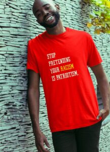 Black man wearing T-shirt that says “Stop pretending that your racism is patriotism.”