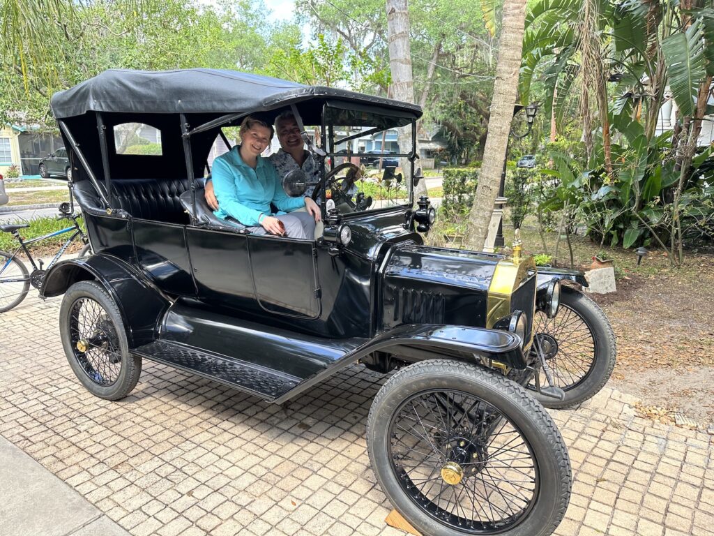 Anitra Pavka and Joey deVilla in a 1916 Ford Model T, seen from the car’s right side.